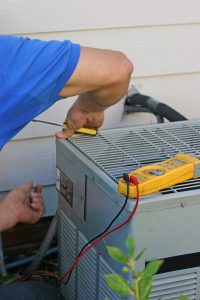 technician working on the outside unit of an air conditioner